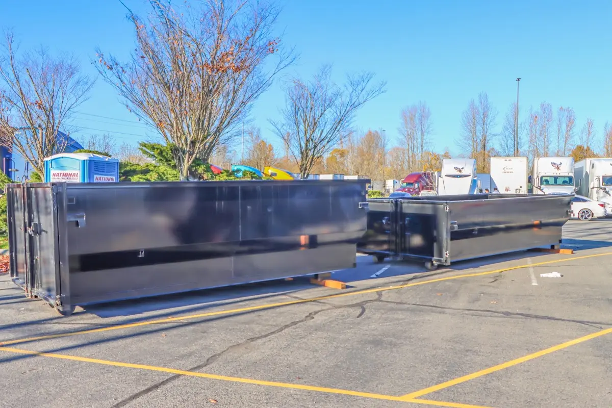 Professional dumpster rental service with roll-off container on residential driveway in California